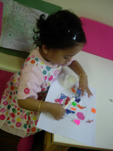 Girl building a collage at Early Learners Nursery School, Leicester